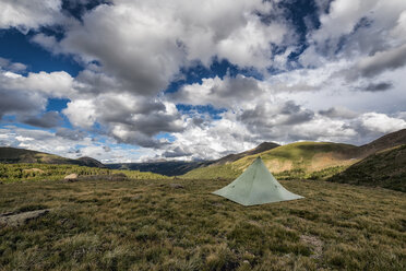 Tent on grassy field against cloudy sky - CAVF58537