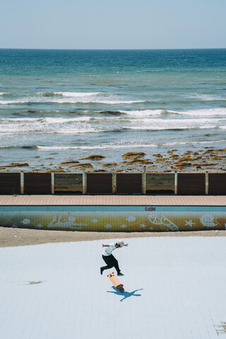 Hohe Winkel Ansicht des Mannes Skateboarding im Park am Meer, lizenzfreies Stockfoto