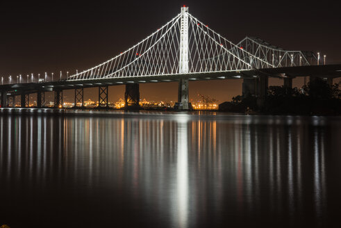 Beleuchtete Oakland Bay Bridge über Treasure Island in der Stadt bei Nacht - CAVF58642
