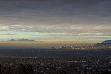 Aerial view of cityscape against cloudy sky during winter - CAVF58707