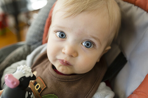 Close-up-Porträt von niedlichen Baby-Junge sitzt auf Hochstuhl zu Hause, lizenzfreies Stockfoto