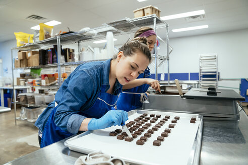 Weibliche Mitarbeiter bereiten in einer Fabrik Pralinen vor - CAVF58805