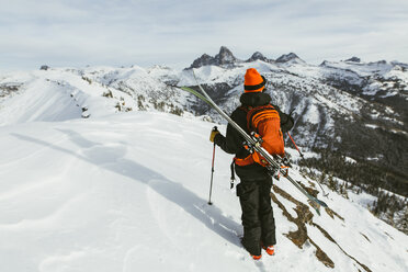 Rückansicht eines Wanderers mit Rucksack und Ski auf einem schneebedeckten Berg - CAVF58878