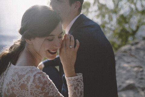 Glückliches Hochzeitspaar am Strand sitzend, lizenzfreies Stockfoto