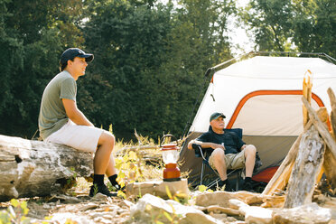 Freunde schauen beim Entspannen auf dem Campingplatz weg - CAVF59006