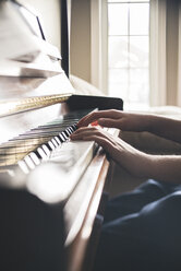 Ausgeschnittenes Bild eines Jungen, der zu Hause Klavier übt - CAVF59093