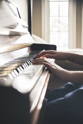 Cropped image of boy practicing piano at home - CAVF59093