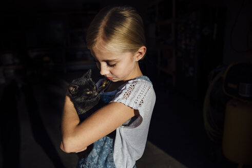 Mädchen hält Katze im Stehen - CAVF59113