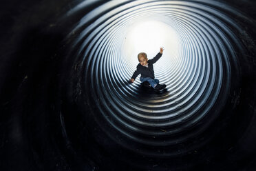 Full length of boy sliding in slide at park - CAVF59128