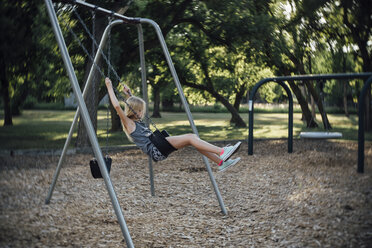 Side view of girl swinging at park - CAVF59132