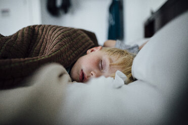 Nahaufnahme von schlafenden Jungen auf dem Bett zu Hause - CAVF59150