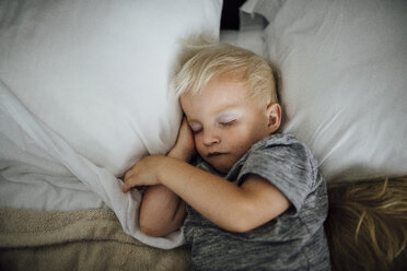 Draufsicht auf einen Jungen, der zu Hause auf dem Bett schläft - CAVF59151