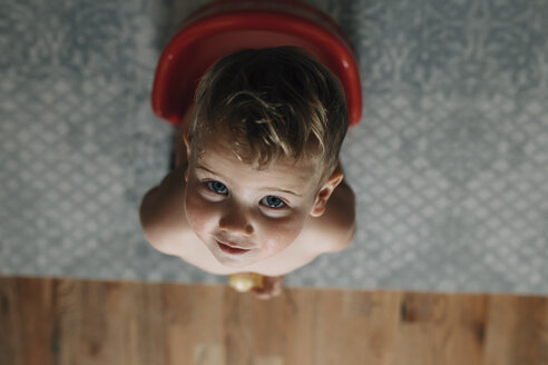 Overhead-Porträt von niedlichen lächelnden Baby-Jungen urinieren, während auf Töpfchen im Wohnzimmer sitzen - CAVF59191