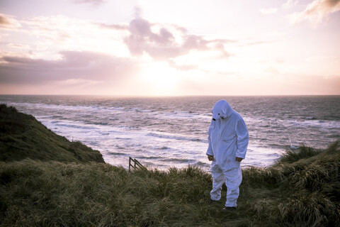Dänemark, Nordjuetland, Mann im Eisbärenkostüm am Strand, lizenzfreies Stockfoto