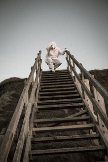 Mann im Eisbärenkostüm auf der Treppe, Verzweiflung - REAF00476