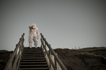 Mann im Eisbärenkostüm auf der Treppe, Verzweiflung - REAF00477