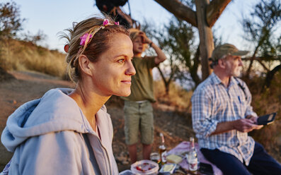 Chile, Santiago, Mutter mit Großvater und Sohn beim Picknick bei Sonnenuntergang - SSCF00088