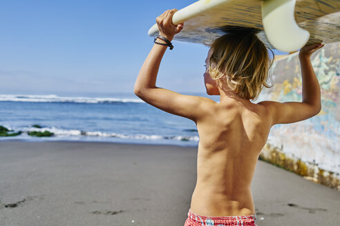 Chile, Pichilemu, Junge mit Surfbrett am Meer - SSCF00117