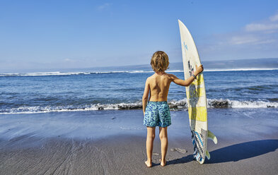 Chile, Pichilemu, boy standing at the sea with surfboard - SSCF00121