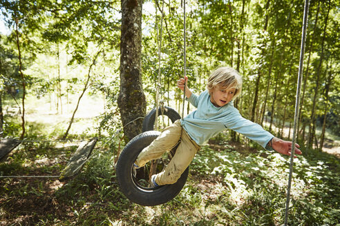 Junge balanciert auf Reifen in einem Abenteuerpark im Wald - SSCF00156