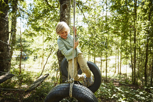 Happy boy balancing on tyres at an adventure park in forest - SSCF00157