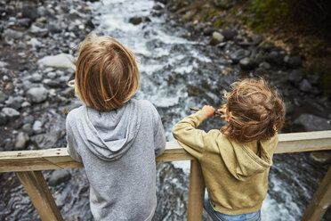 Chile, Patagonien, Vulkan Osorno, Wasserfall Las Cascadas, zwei Jungen stehen auf einer Brücke über einem Fluss - SSCF00177