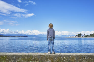 Chile, Puerto Montt, boy standing on quay wall at the harbor - SSCF00182