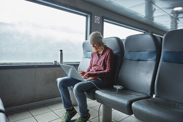 Chile, Hornopiren, woman using laptop in a ferry - SSCF00191