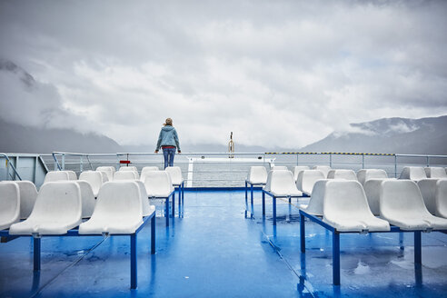 Chile, Hornopiren, Frau steht an der Reling einer Fähre und schaut auf den Fjord - SSCF00195