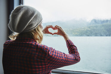 Chile, Hornopiren, woman shaping a heart with her hands at the window of a ferry - SSCF00201