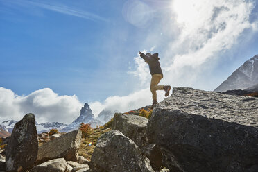 Chile, Cerro Castillo, boy jumping from rock in mountainscape - SSCF00236