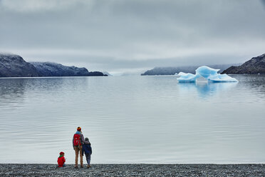 Chile, Torres del Paine Nationalpark, Lago Grey, Frau mit zwei Söhnen steht am Ufer und schaut auf einen Eisberg - SSCF00275