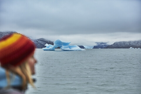 Chile, Torres del Paine National Park, Lago Grey, Frau am Ufer mit Eisbergen im Wasser, lizenzfreies Stockfoto