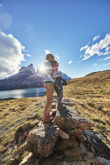 Chile, Torres del Paine National Park, Mutter und Sohn stehen auf einem Felsen vor dem Torres del Paine Massiv bei Sonnenaufgang - SSCF00287