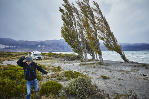 Argentina, Lago Posadas, boy running at the lake in storm - SSCF00290