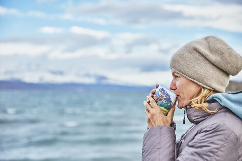 Chile, Torres del Paine National Park, Frau trinkt aus Becher am Lago Paine - SSCF00292