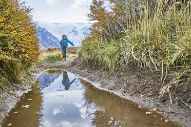 Argentinien, Patagonien, El Chalten, Junge läuft an einer Pfütze am Cerro Torre im Los Glaciares National Park - SSCF00306