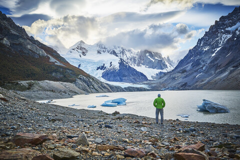 Argentinien, El Chalten, Mann steht am Gletschersee und schaut zum Cerro Torre, lizenzfreies Stockfoto