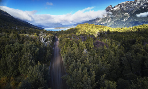 Argentinien, Patagonien, Lago Futalaufquen, Drohnenbild von Schotterstraße durch Wald, lizenzfreies Stockfoto