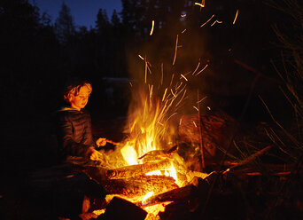 Argentinien, Patagonien, Lago Futalaufquen, Junge am Lagerfeuer bei Nacht - SSCF00333