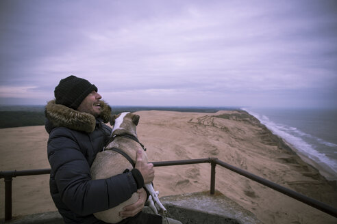 Dänemark, Nordjütland, Leuchtturm Rubjerg Knude, lachender Mann und sein Hund zur blauen Stunde - REAF00487