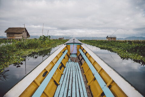 Boot auf dem Inle-See vor bewölktem Himmel, lizenzfreies Stockfoto