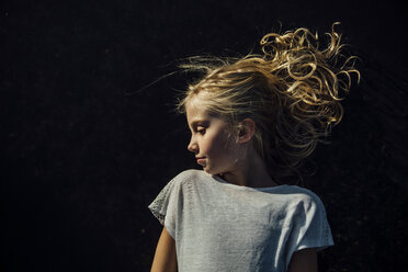 Girl looking away while standing against black background - CAVF59347