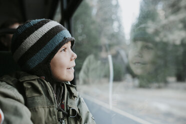 Smiling boy looking through window in tour bus at Yosemite National Park - CAVF59350