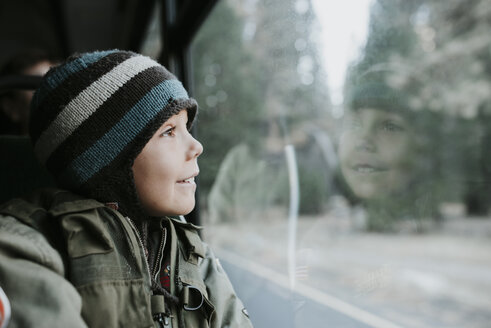 Lächelnder Junge schaut durch das Fenster eines Reisebusses im Yosemite National Park - CAVF59350