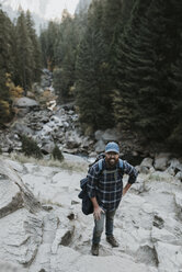 High angle portrait of man standing on mountain at Yosemite National Park - CAVF59351