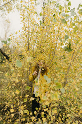 Frau inmitten von Pflanzen im Herbst stehend - CAVF59394