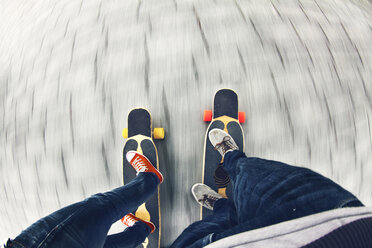 Niedriger Ausschnitt eines Skateboard fahrenden Paares auf der Straße - CAVF59444