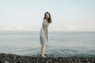 Portrait of cheerful woman standing in river against sky - CAVF59466