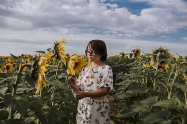 Girl standing in sunflower field against sky - CAVF59492